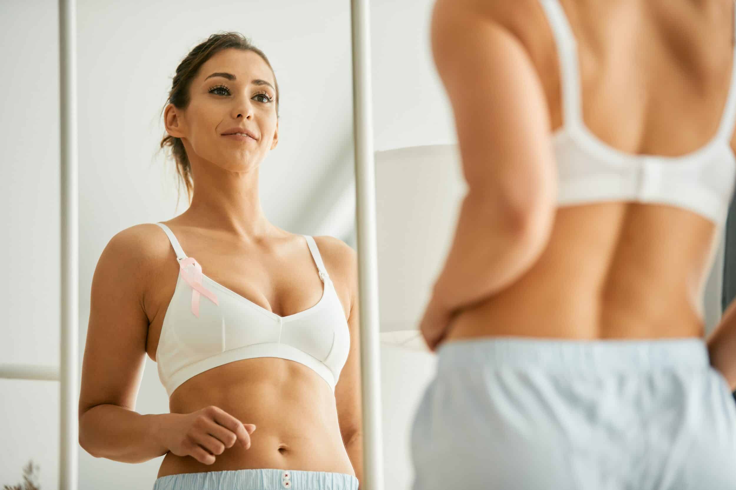 Woman in bra looking in the mirror after breast reconstruction surgery in Northbrook, IL