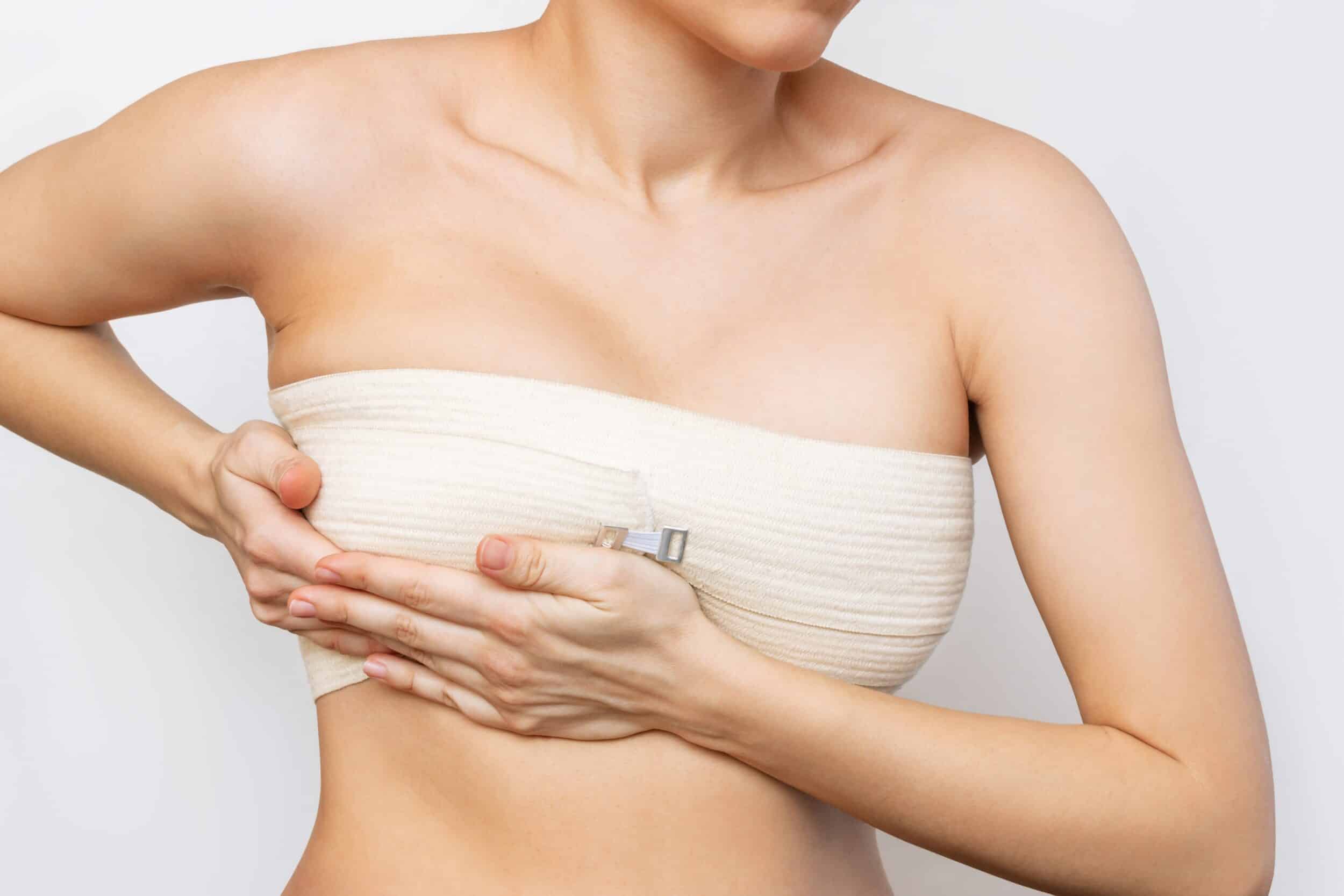 Close up of woman's breasts in compression bra during breast lift recovery in Northbrook, IL